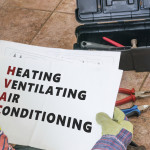 Repairman is looking at documentation of HVAC (Heating, Ventilat